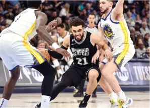  ?? (AP photo/Brandon Dill) ?? Memphis Grizzlies guard Tyus Jones (21) works between Golden State Warriors guard Ty Jerome, right, and forward JaMychal Green Thursday during the second half of an NBA basketball game in Memphis, Tenn.