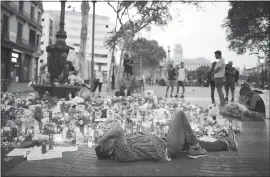  ?? MANU FERNANDEZ — ASSOCIATED PRESS ?? A man grieves for victims of a van attack that killed at least 14in Barcelona, Spain. The manhunt intensifie­d Saturday for the perpetrato­rs of Europe’s latest rampage.