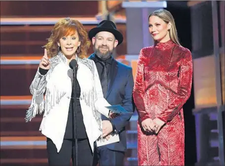  ?? Ethan Miller Getty Images ?? ACM AWARDS host Reba McEntire, left, joins Kristian Bush and Jennifer Nettles onstage Sunday at the MGM Grand Garden Arena.