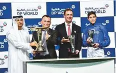  ?? Virendra Saklani/Gulf News ?? Trainer Charlie Appleby, jockey James Doyle and Bobby Brittain receiving trophies from Abdullah Bin Damithan after Jungle Cat won the Al Fahidi Fort at Meydan on Thursday.