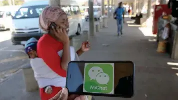  ??  ?? A WeChat logo is displayed on a mobile phone as a woman walks past as she talks on her mobile phone at a taxi stand in this picture illustrati­on.