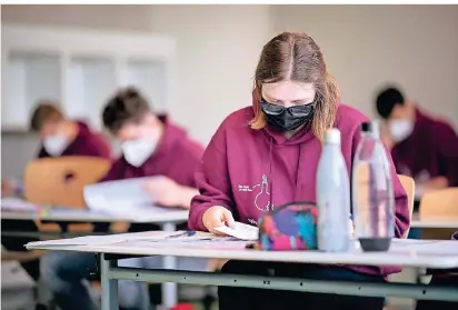  ?? FOTO: DPA ?? Über vier Stunden mit Maske die Abiturprüf­ungen schreiben: gar nicht so einfach.