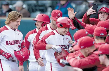  ?? NWA Democrat-Gazette/ANDY SHUPE ?? Arkansas second baseman Carson Shaddy celebrates with teammates while wearing a Hog hat Friday after hitting a three-run home run during the second inning of the Razorbacks’ 14-2 victory over Bucknell at Baum Stadium in Fayettevil­le. The Razorbacks...