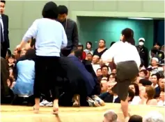  ??  ?? A photo grab from a YouTube video shows women climbing up a sumo ring to treat Maizuru city mayor Ryozo Tatami, who collapsed while making a speech in a gym in Maizuru, Kyoto prefecture, Japan. — Reuters photo