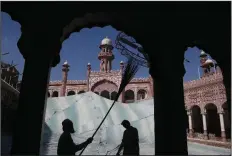  ?? (AP/Muhammad Sajjad) ?? Volunteers clean the outer areas of the historic Mohabat Khan Mosque ahead of the Muslim fasting month of Ramadan, in Peshawar, Pakistan. Muslims are in the midst of their second Ramadan, which began Monday in the midst of the covid-19 pandemic.