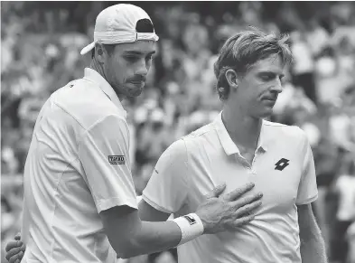  ?? GLYN KIRK / THE ASSOCIATED PRESS ?? John Isner, left, and Kevin Anderson John Isner meet up at the net following their epic five-set semifinal match.