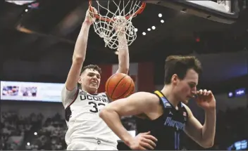  ?? JESSICA HILL VIA AP ?? UCONN CENTER DONOVAN CLINGAN dunks behind Marquette guard Tyler Kolek (11) in the first half of a game on Saturday in Hartford, Conn.