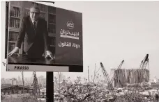  ?? AFP ?? An electoral billboard for Najib Lyan, a candidate in Sunday’s vote, next to the Beirut harbour’s damaged grain silos