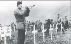  ??  ?? In this August 1943 file photo, a bugler sounds taps during a memorial service while a group of G.I.s visit the graves of comrades who fell in the reconquest of Attu Island, part of the Aleutian Islands of Alaska. May 30, will mark the 75th anniversar­y...