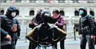  ?? JOHANNES EISELE / AFP ?? Top: Tourists wearing face masks stand outside the New York Stock Exchange on Feb 3.