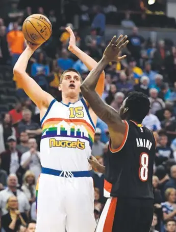  ??  ?? Nuggets center Nikola Jokic takes a shot over the Trail Blazers’ Al-Farouq Aminu during the first quarter Saturday night at the Pepsi Center. John Leyba, The Denver Post