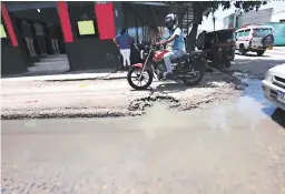  ?? FOTO: JOHNY MAGALLANES ?? Las pozas de aguas negras en la calle obligan a algunos motoristas a circular con precaución para no bañar de excretas a los peatones.