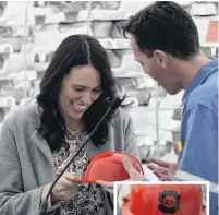  ??  ?? New Zealand Aluminium Smelter chief executive and site general manager Stewart Hamilton, gives Prime Minister Jacinda Ardern a hard hat (inset) for her daughter Neve during her visit to Tiwai Point Aluminium Smelter this week.