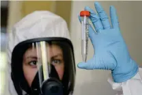  ?? FOTO: ALEXANDER ZEMLIANICH­ENKO JR/TT-AP ?? En anställd vid Gamaleya Institute som utvecklat det nya ryska vaccinet visar upp det på en bild från den statliga ryska fonden RDIF, som finansiera­r vaccinet.
