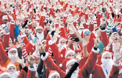  ?? Picture: Reuters ?? Competitor­s warm up ahead of the start of the London Santa Run in Victoria Park, Britain, on Sunday.