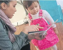  ??  ?? Caseworker Stephanie Taveras reads a book with 20-month-old Gracey Niebla at the child’s home in Providence, Rhone Island, the US.