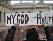  ?? SETH WENIG — THE ASSOCIATED PRESS FILE ?? A woman holds a sign during a protest at the state house in Trenton, N.J.