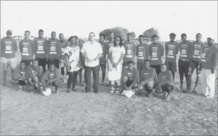  ??  ?? UK based Guyanese Anthony Price (centre) posing with members of the Trafalgar United FC, inclusive of Club Coordinato­r Yvette Price, after a simple presentati­on of football kits and equipment at the No. #30 Ground in West Coast of Berbice. The...