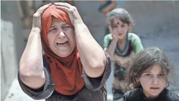  ?? ASSOCIATED PRESS ?? A woman screams while fleeing with her family through a destroyed alley Sunday as Iraqi Special Forces continue their advance against Islamic State militants in Mosul’s Old City.