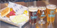  ?? ADOLPHE PIERRE LOUIS/JOURNAL ?? Nexus Blue Smokehouse offers a variety of options, including a pulled-pork sandwich with potato salad, and, from left, scotch ale, imperial cream ale and mango milkshake India pale ale.