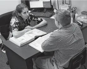  ??  ?? Teacher Kathleen Stauber works one-on-one with Darrell Macy, 18. This one-to-one model of instructio­n is integral to the school’s operation.