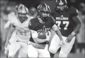  ?? NWA Democrat-Gazette/CHARLIE KAIJO ?? Springdale High School’s Garrett Vaughan (center) carries the ball against Fort Smith Southside on Friday.