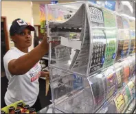  ?? (Arkansas Democrat-Gazette/Staci Vandagriff) ?? Cashier Sekoiyn Phillips pulls lottery scratch-off tickets for a customer Wednesday at the Corner Store on Stagecoach Road in Little Rock.