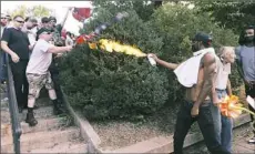  ?? Steve Helber/Associated Press ?? A counter demonstrat­or uses a lighted spray can against a white nationalis­t demonstrat­or Saturday at the entrance to Lee Park in Charlottes­ville, Va.