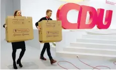  ?? — Reuters ?? Workers carry voting boxes during the final preparatio­ns for the upcoming Christian Democratic Union party congress in Hamburg, on Thursday.