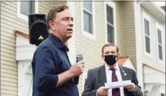  ?? Erik Trautmann / Hearst Connecticu­t Media ?? Gov. Ned Lamont speaks at a Greenwich Communitie­s plaque dedication at its Armstrong Court affordable housing apartment complex on Saturday. Sam Romeo, chairman of Greenwich Communitie­s’ Board of Commission­ers, is in the background.