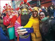  ?? YU GUO / FOR CHINA DAILY ?? Center: Spectators take photos with dancers during the Chinese New Year parade in London.