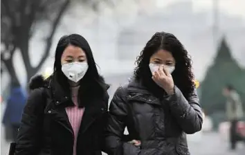 ?? AP ?? Environmen­tal challenge Women wear masks for protection against pollution in Beijing yesterday. China is enlisting technology in its fight to balance economic growth with best environmen­tal practices.
