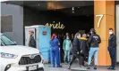  ?? Photograph: Asanka Ratnayake/Getty Images ?? Health and social workers wearing masks and PPE at the entrance of the Ariel apartment complex.