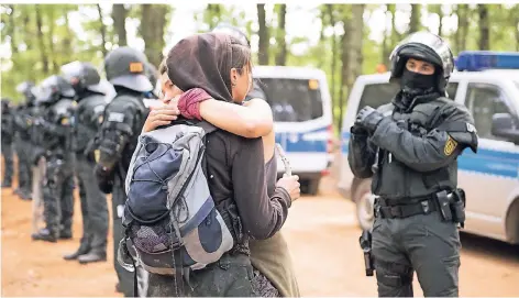  ?? FOTO: IMAGO ?? Im Hambacher Forst: Aktivisten umarmen sich vor einer Polizeiket­te. Die Polizei treibt die Räumung des Waldes voran.