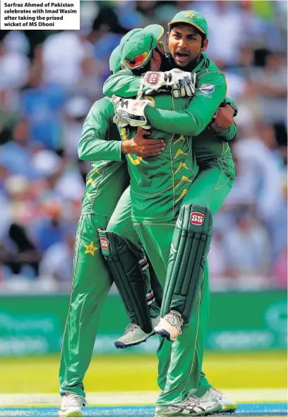  ??  ?? Sarfraz Ahmed of Pakistan celebrates with Imad Wasim after taking the prized wicket of MS Dhoni