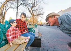  ?? GABRIELA CAMPOS THE NEW MEXICAN ?? Ventriloqu­ist Paolo Alexander Buis, 10, and his dummy Charles Alexander McCarthy make friends with Justin Brit on Friday on the Plaza.
