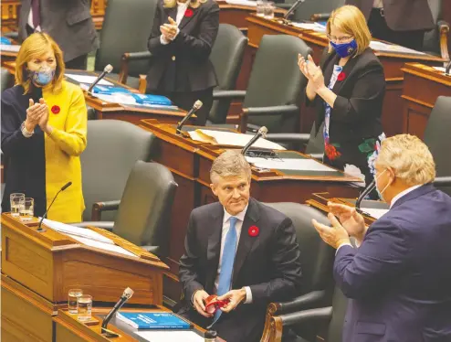  ?? FRANK GUNN / THE CANADIAN PRESS ?? Ontario Finance Minister Rod Phillips, left, has described the budget as “workmanlik­e” and wore a pair of boots to drive home the point.