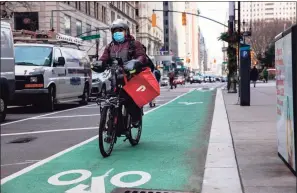  ?? Michael Nagle / Bloomberg ?? A bike messenger carries a DoorDash Inc. bag during a delivery in New York on Dec. 9, 2020.