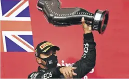  ?? DPA-BILD: Medina ?? Er gibt die Richtung vor: Lewis Hamilton freut sich mit dem Pokal in der Hand über seinen Sieg.