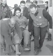  ?? GETTY IMAGES/SANA ?? Syrian Red Crescent workers help a civilian exit the bus after being evacuated from the besieged city of Homs.
A total of 420 people were evacuated.