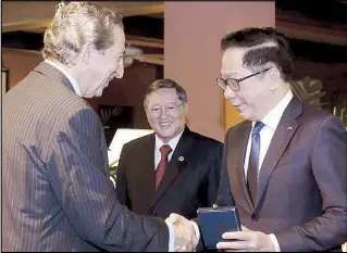  ??  ?? Tycoon Andrew Tan (right) is congratula­ted by Spanish Ambassador Luis Calvo after receiving the Encomienda de Numero de la Orden del Merito Civil from the Spanish government during a ceremony at the ambassador’s residence in Forbes Park, Makati last...