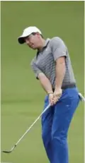  ??  ?? CHARLOTTE: Rory McIlroy of Northern Ireland, chips to the 18th green during a practice round at the PGA Championsh­ip golf tournament at the Quail Hollow Club Tuesday, in Charlotte. — AP