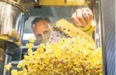  ??  ?? Jimmy Pater scoops popcorn at Cinépolis Luxury Cinemas Del Mar on Saturday.