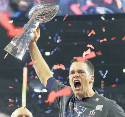  ?? Picture / AP ?? Iron-willed Patriots quarterbac­k Tom Brady hoists the Lombardi Trophy.