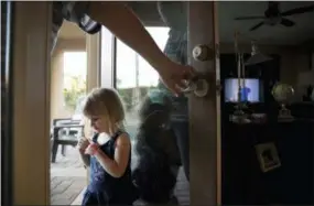  ?? AP PHOTO/JAE C. HONG ?? Doug Biggers, whose 20-year-old son, Landon, died of opioid overdose in 2017, holds the backyard door open for Landon’s 2-year-old daughter, Aubrey, in La Quinta, Calif.