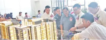  ??  ?? Jaujan, Junz (third right) and George (second left) viewing a scale model of K-Avenue that comprises three 21-storey tower blocks.