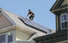  ?? Hardy Wilson / The Chronicle 2009 ?? A Sungevity worker installs solar panels in San Francisco.