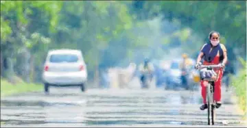  ?? RAVI KUMAR/HT ?? HEAT WAVE ALERT: A mirage caused on a road by the hot weather in Chandigarh on Sunday. Also called heat haze, this fake pool of water is experience­d due to variation between the hot air at the surface of the road and the denser cool air above it.