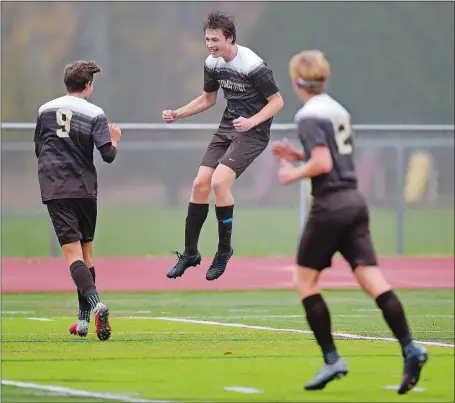  ?? SEAN D. ELLIOT/THE DAY ?? Stonington’s Will Cannella, center, races to celebrate a goal with Sam Montalto, left, in the first half of Tuesday’s Class M boys’ soccer state tournament game against New Fairfield.