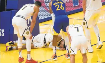  ?? JEFF CHIU/AP ?? The Nuggets were dealt a big blow when point guard Jamal Murray tore the ACL in his left knee in the final minute of Monday’s loss to the Warriors. He’s out indefinite­ly.